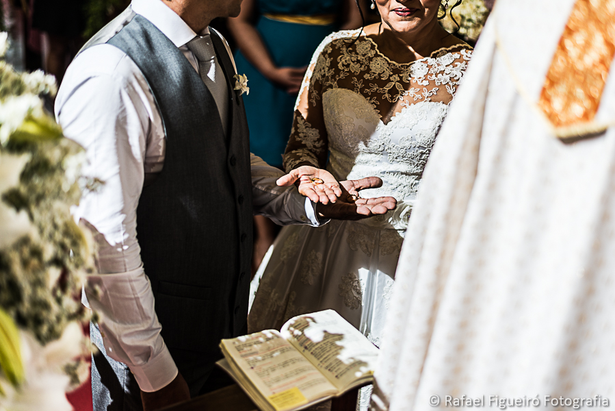 Bênção das alianças noivos segurando as alianças fotografado por Rafael Figueiró melhor fotógrafo de casamentos de Recife-PE