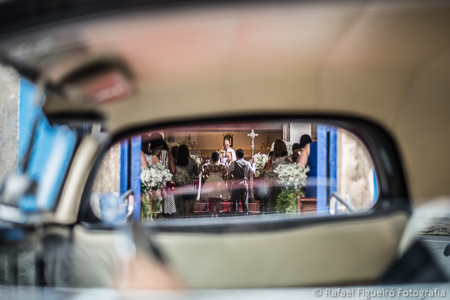 Vista em perspectiva através da janela do carro antigo dos noivos no altar dentro da igreja fotografado por Rafael Figueiró melhor fotógrafo de casamentos de Recife-PE