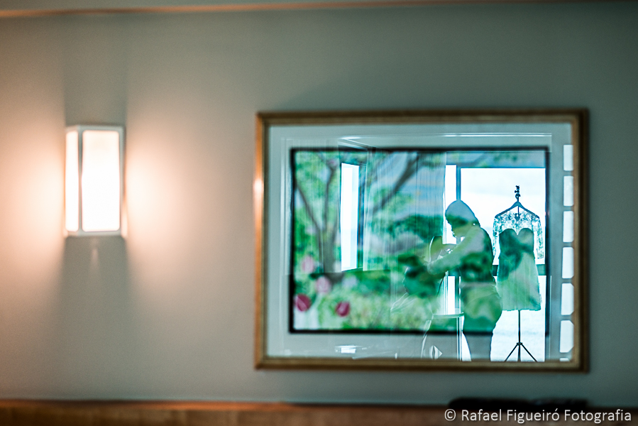 Reflexo da maquiadora produzindo a noiva no quadro da parede do quarto fotografado por Rafael Figueiró melhor fotógrafo de casamentos de Recife-PE