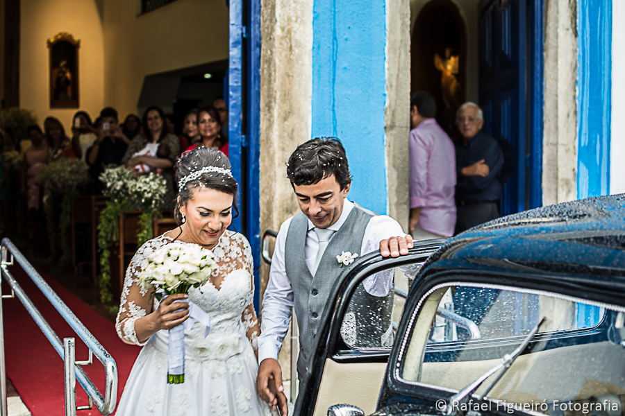 Noivo gentilmente abrindo a porta do carro ford 1937 para a entrada da noiva cheios de arroz na cabeça rafael figueiró fotógrafo de casamentos em recife