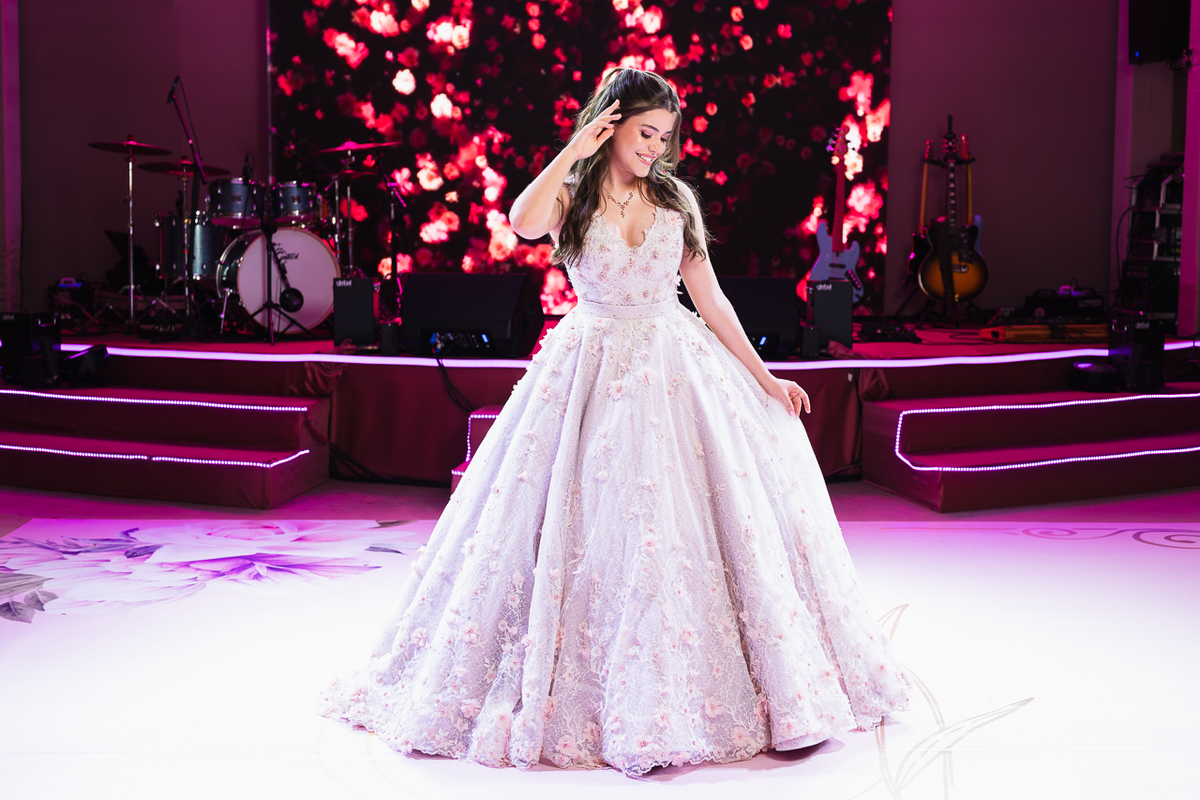 Foto da Debutante Laura em frente a pista de dança e palco da festa dos quinze anos da Laura Macedo.