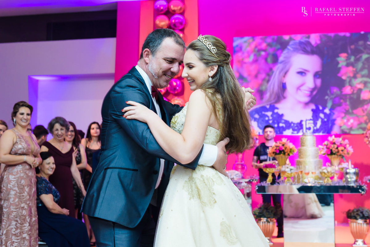 Laura dança valsa com seu tio na festa de 15 anos.