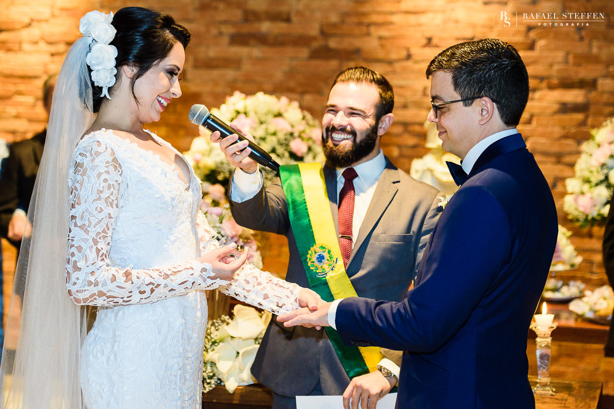 Noiva emocionada coloca aliança no dedo do noivo durante a cerimônia de casamento de Anny e Marlon no restaurante Coco Bambu do Lago Sul fotografado por Rafael Steffen.