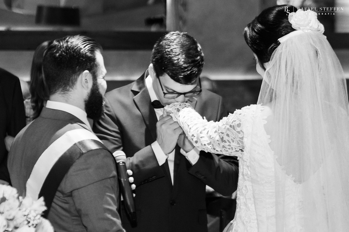 Noivo beija a mão da noiva Anny durante cerimônia de casamento no restaurante Coco Bambu em Brasília fotografado por Rafael Steffen Fotografia.