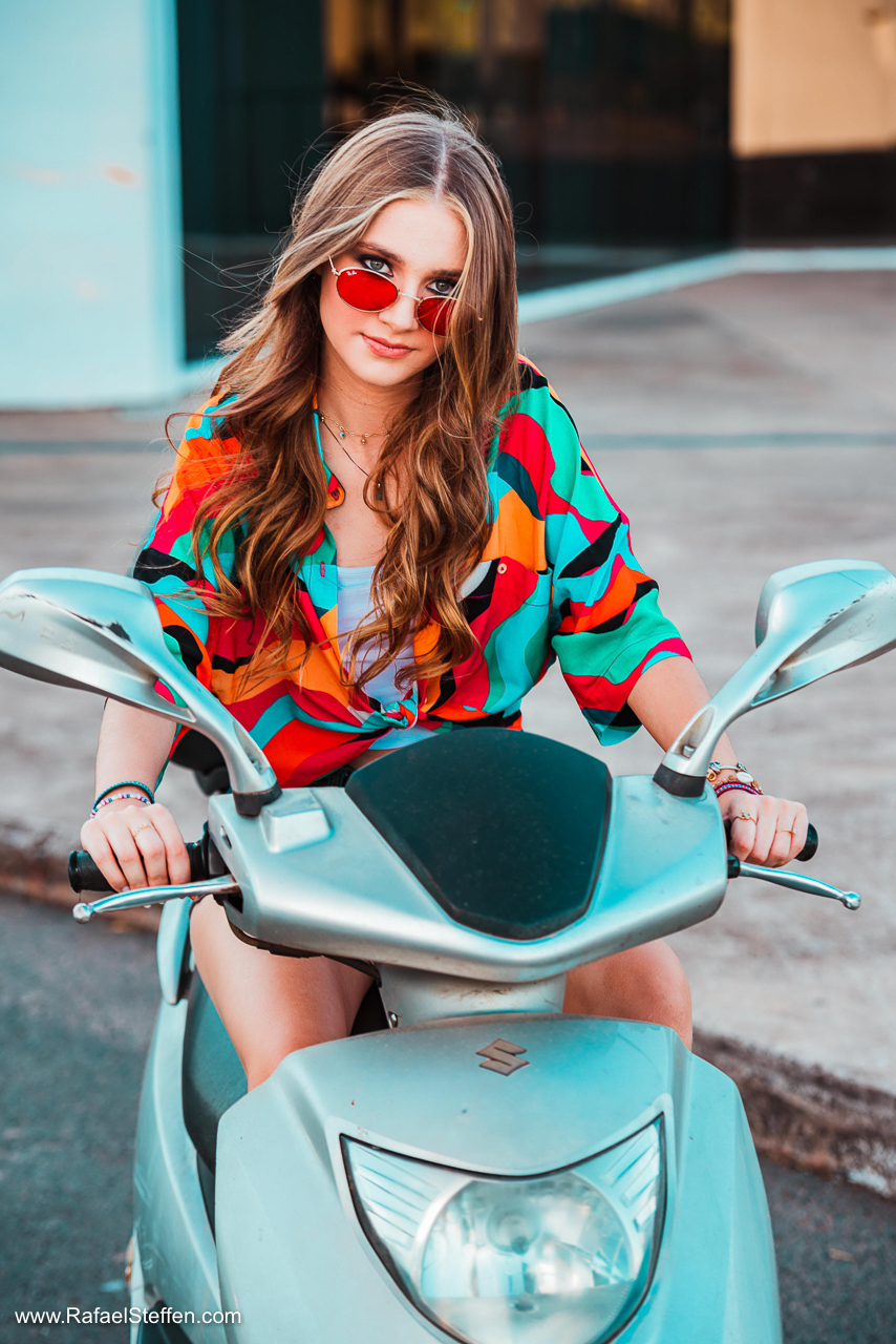 Ensaio de quinze anos da Ester sentada sobre uma moto estacionada no Museu Nacional da República em Brasília.