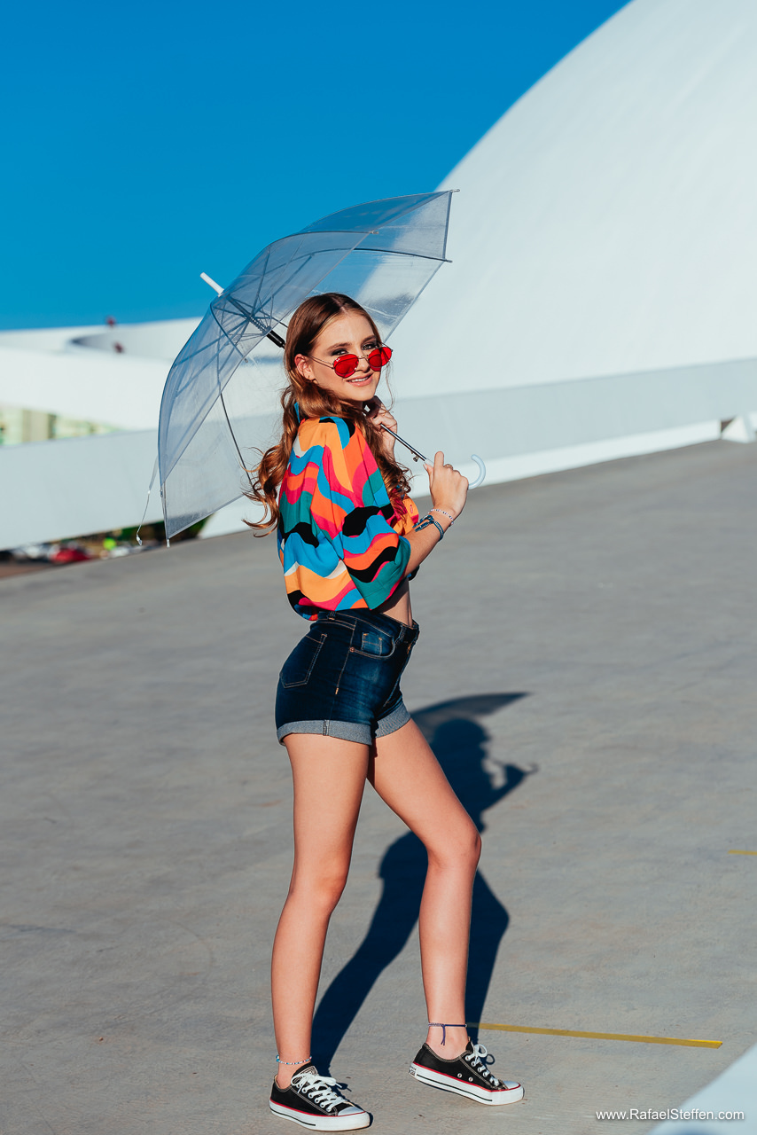 Foto de debutante com sombrinha transparente na rampa de acesso do Museu da República em Brasília.