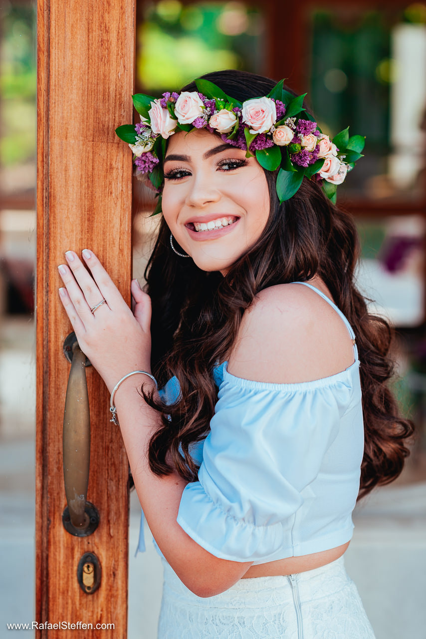 Foto do ensaio de quinze anos da Débora com a coroa de flores no cabelo fotografado em Brasília - DF.