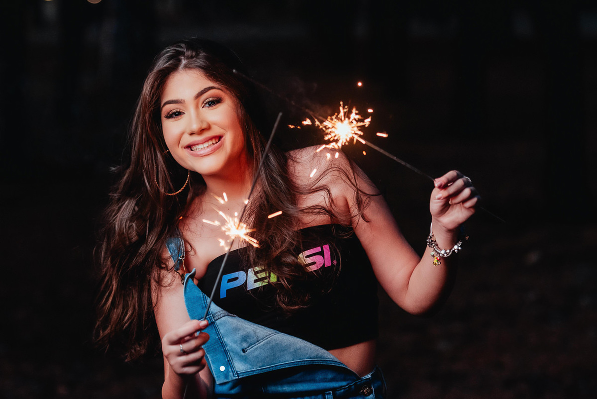 Ensaio de quinze anos com sparkles na mão.