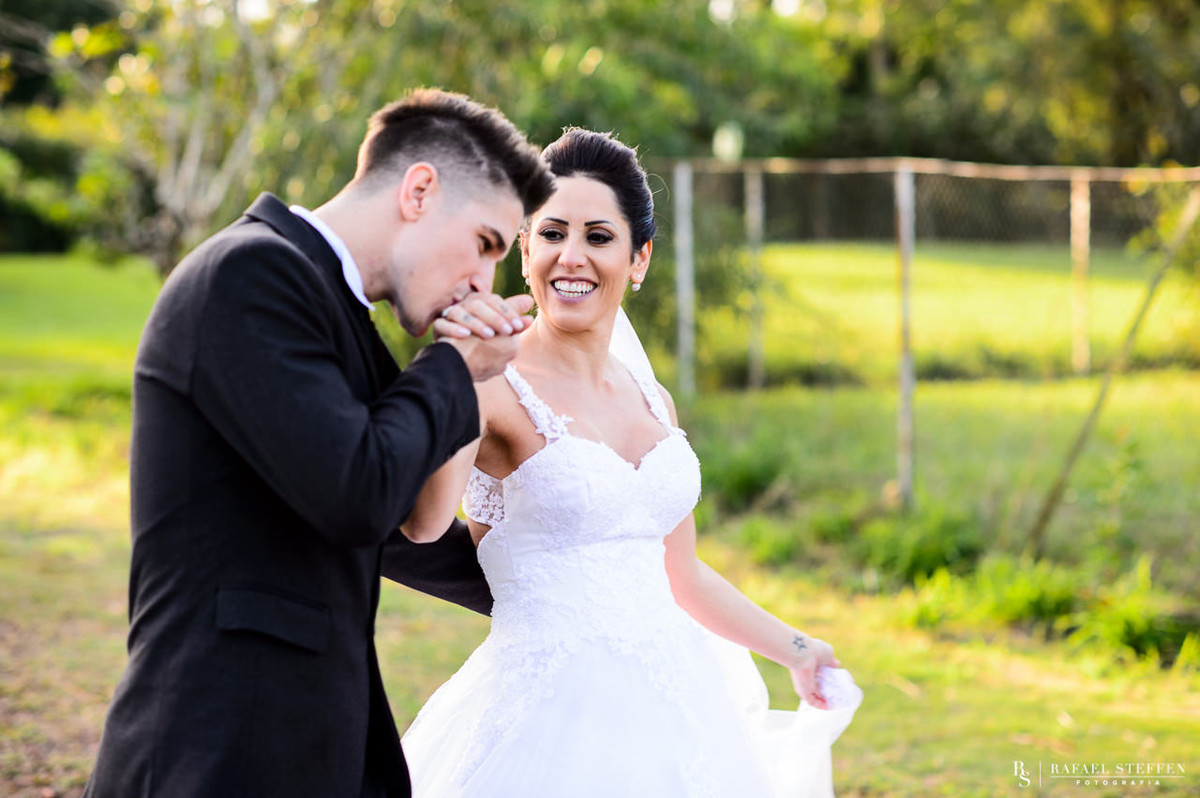 Beijo do noivo na mão da noiva