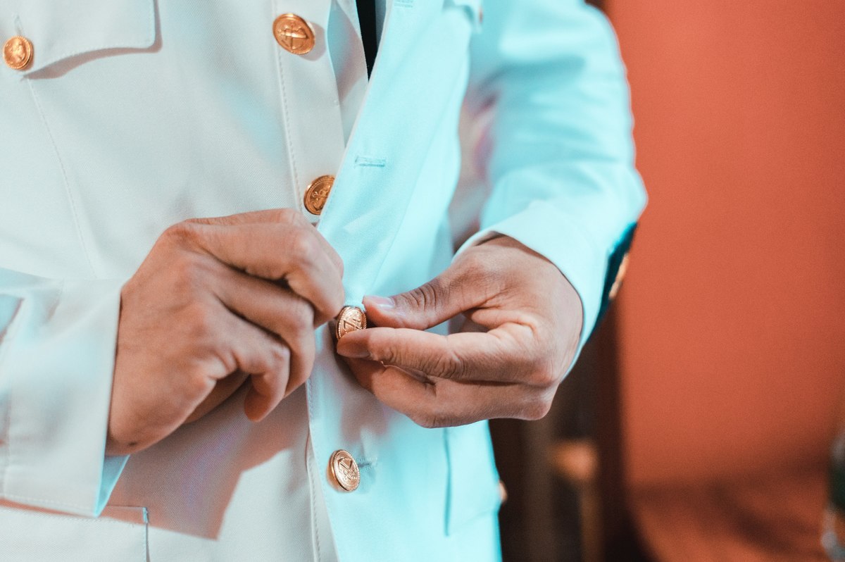novio colocándose traje militar para la boda