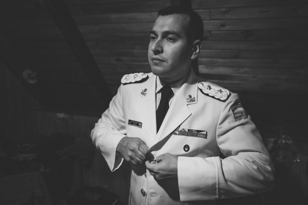 novio abotonándosela el traje militar