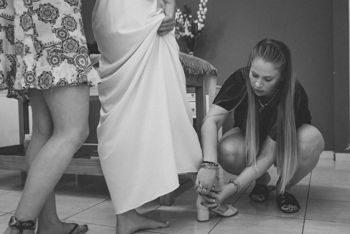 detalles de las novia amiga colocando zapatos