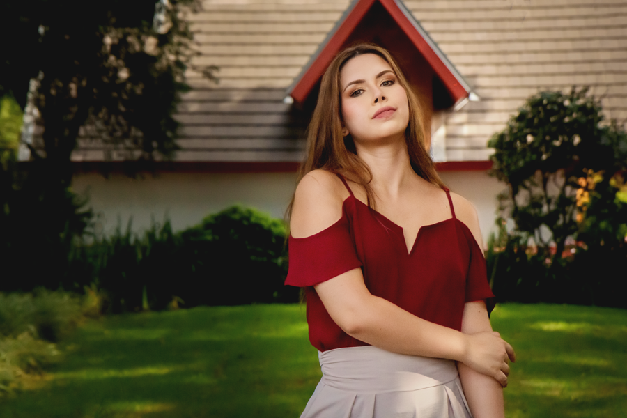 fotos em dois irmaos-sessao fotografica em dois irmaos-fotos na praca dos imigrantes em dois irmaos-sessao fotografica na praca dos imigrantes em dois irmaos-fotografia feminina-mulher em pe com blusa vermelha em um gramado na praca dos imigrantes