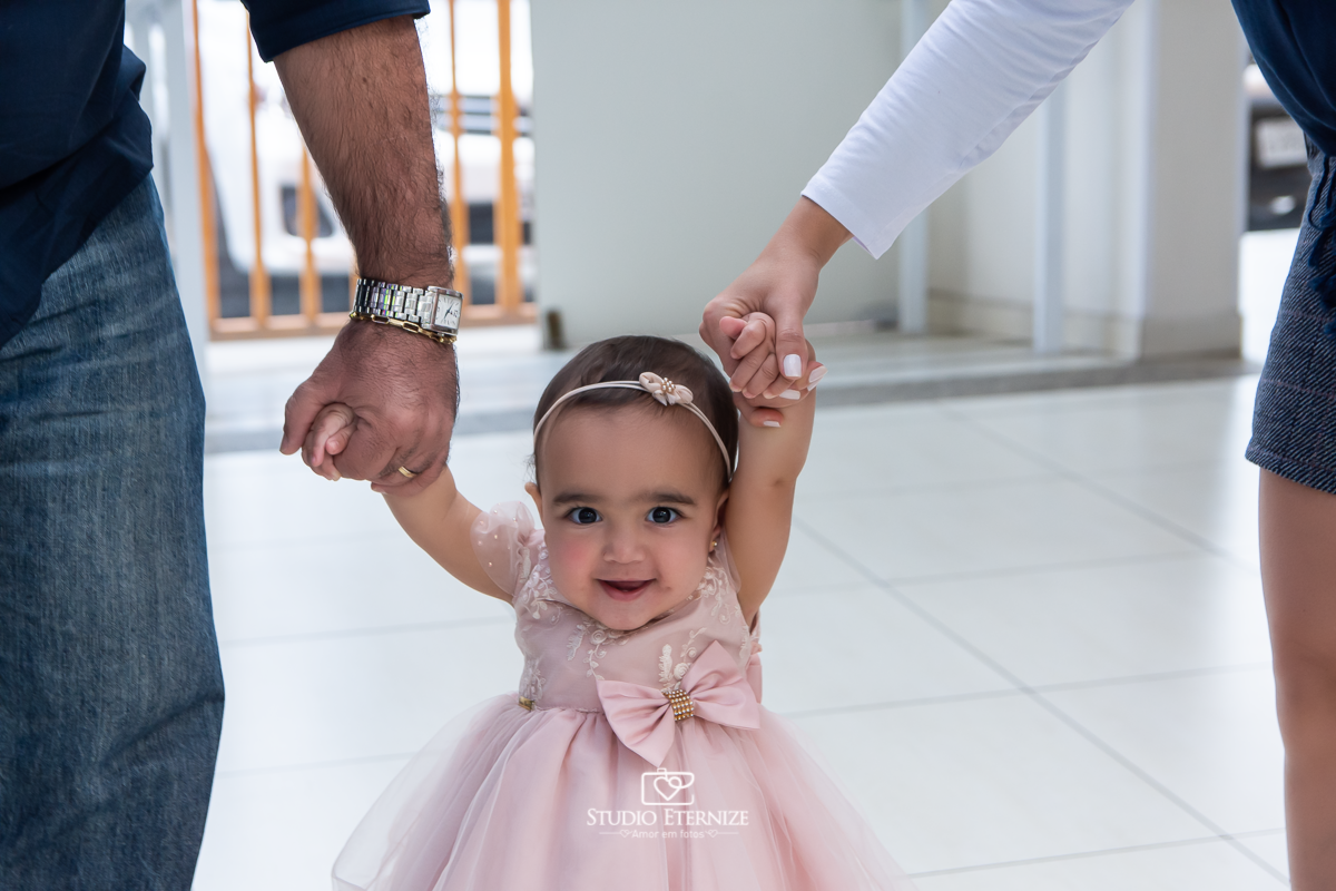 Fotografia da aniversariante Giovanna chegando com seus pais na sua festa.