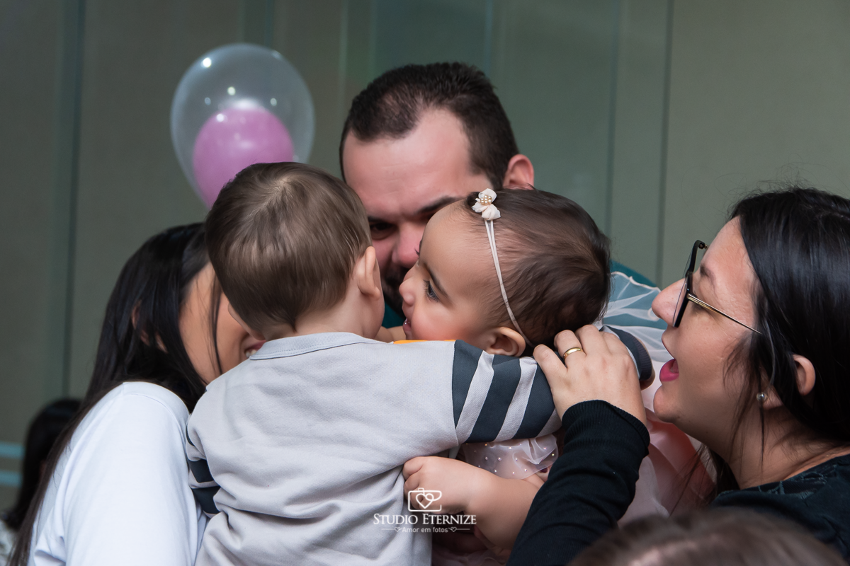 Fotografia da aniversariante abraçando seu amiguinho.