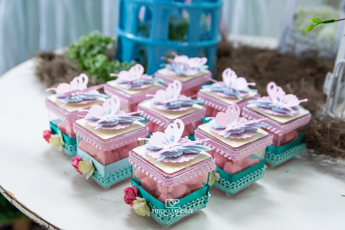 Fotografia do aniversário de 1 ano da Giovanna realizado no Buffet Fábrica da Diversão. Detalhe da decoração da mesa com caixinhas de doce.