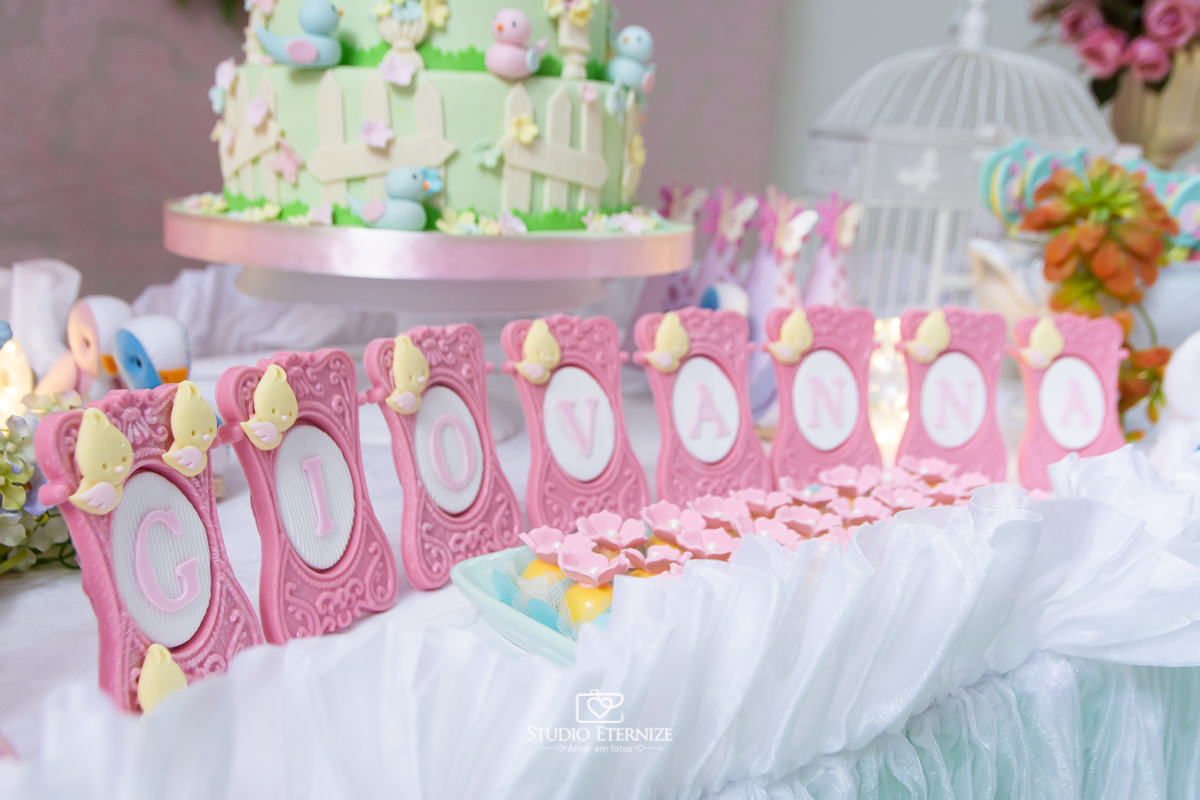 Fotografia do aniversário de 1 ano da Giovanna realizado no Buffet Fábrica da Diversão. Detalhe da decoração da mesa com o nome da aniversariante.