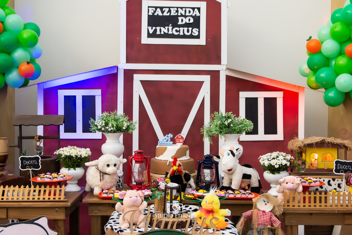 Fotografia de aniversario infantil no tema fazendinha. Decoração da mesa do bolo.