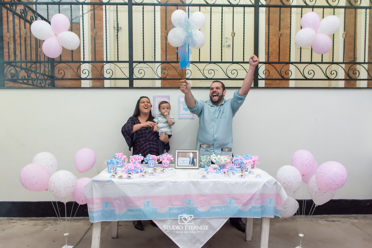 Fotografia de aniversario infantil no tema fazendinha realizado em Poços de 
 Caldas. Pais e aniversariante na mesa da descoberta do sexo do próximo bebê descobrindo que o próximo bebê é um menino.