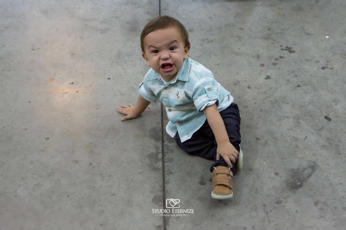 Fotografia de aniversario infantil no tema fazendinha realizado em Poços de Caldas. Aniversariante engatinhando no chão e fazendo caretinha.