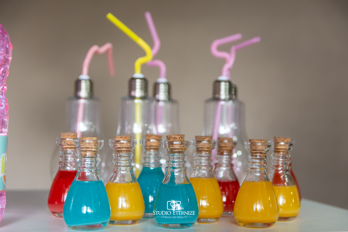 Fotografia de aniversário infantil realizado pelo Studio Eternize em Poços de Caldas. Tema da festa cientista. Detalhe com lâmpadas de decoração e vidrinhos com suco colorido.