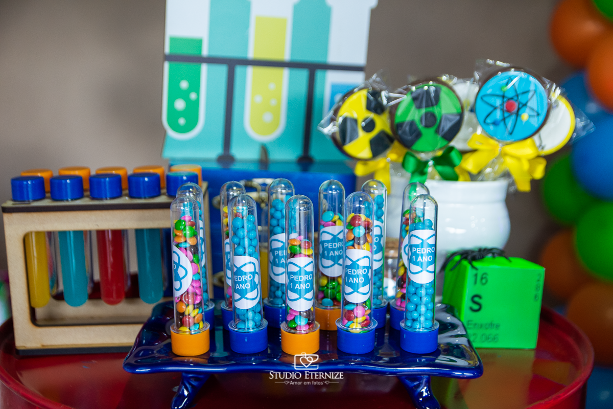 Fotografia de aniversário infantil realizado pelo Studio Eternize em Poços de Caldas. Tema da festa cientista. Detalhe da decoração com tubetes de balinha colorida.