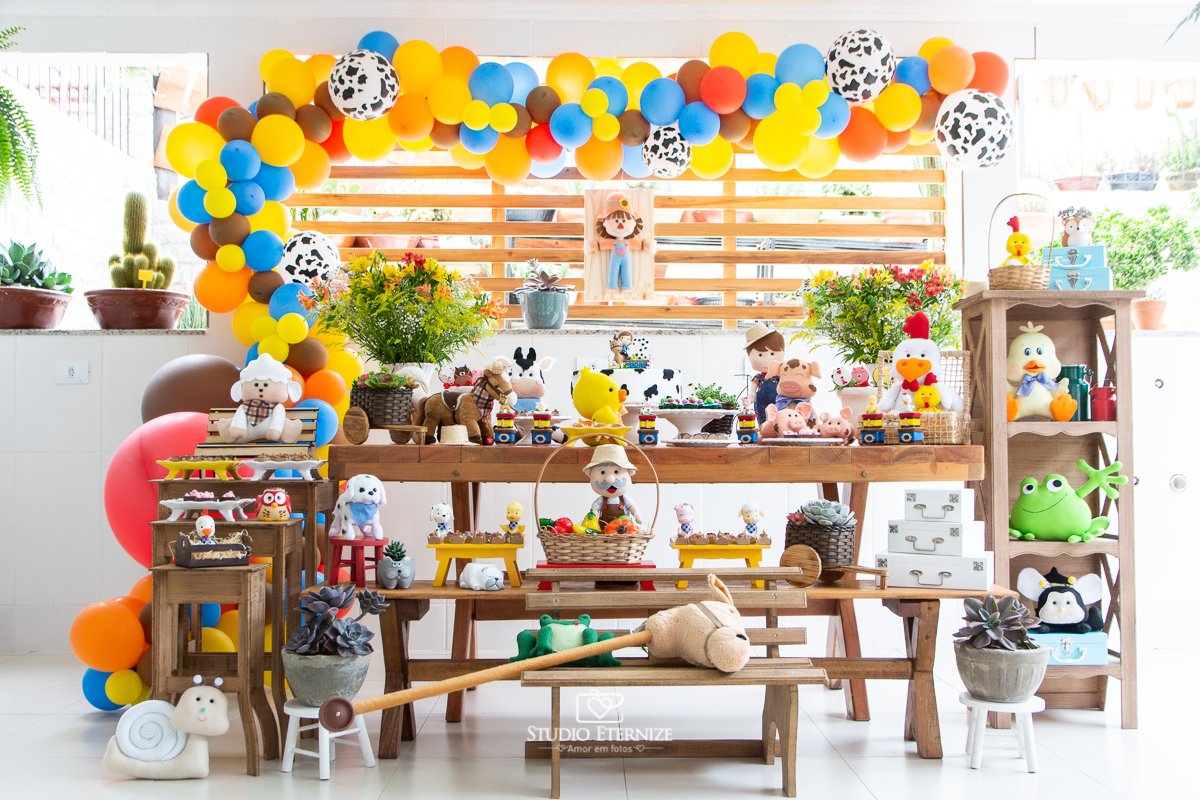Fotografia de festa infantil de 2 anos registrada pelo Studio Eternize no tema da fazendinha em Poços de Caldas - MG. Decoração da mesa do bolo no tema fazendinha.