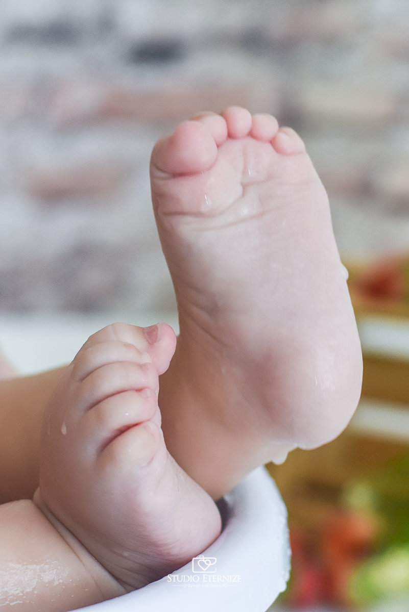 Fotografia de acompanhamento mensal do bebê realizada no Studio Eternize em Poços de Caldas - MG. Detalhe dos pés da bebê menina com 6 meses de idade.