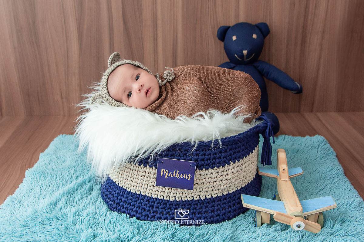 Fotografia newborn menino realizada pelo Studio Eternize em Poços de Caldas - MG. Bebê enroladinho com touca de urso.