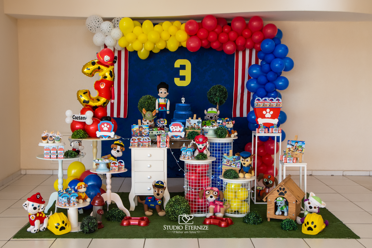 Fotografia de festa infantil de 3 anos registrada pelo Studio Eternize no tema da Patrulha Canina em no Buffet Cata-Vento em Poços de Caldas - MG. Decoração da mesa do bolo.