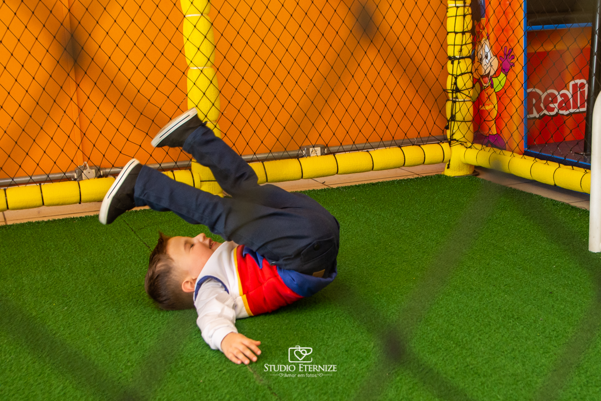 Fotografia de festa infantil de 3 anos registrada pelo Studio Eternize no tema da Patrulha Canina em no Buffet Cata-Vento em Poços de Caldas - MG. Aniversariante brincando de jogar bola.