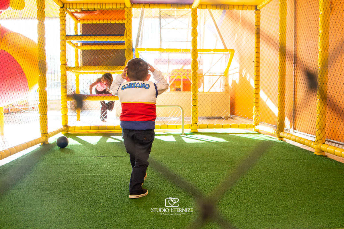 Fotografia de festa infantil de 3 anos registrada pelo Studio Eternize no tema da Patrulha Canina em no Buffet Cata-Vento em Poços de Caldas - MG. Aniversariante brincando de jogar bola.