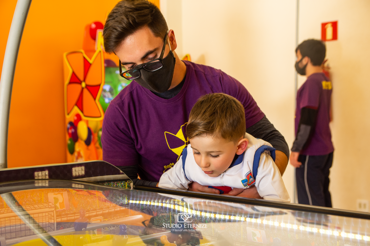 Fotografia de festa infantil de 3 anos registrada pelo Studio Eternize no tema da Patrulha Canina em no Buffet Cata-Vento em Poços de Caldas - MG. Aniversariante brincando na mesa de pebolim.
