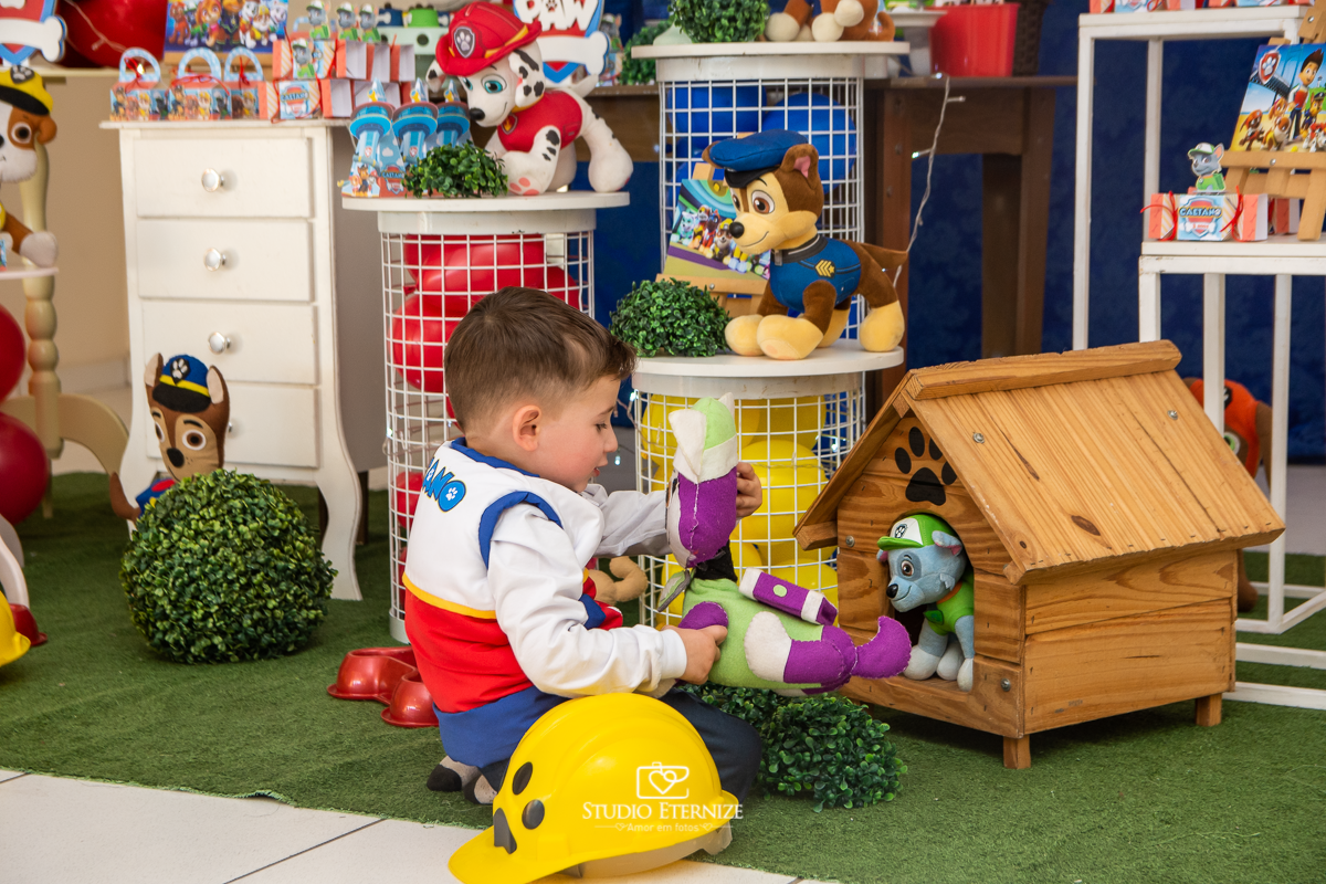 Fotografia de festa infantil de 3 anos registrada pelo Studio Eternize no tema da Patrulha Canina em no Buffet Cata-Vento em Poços de Caldas - MG. Aniversariante brincando com a decoração.