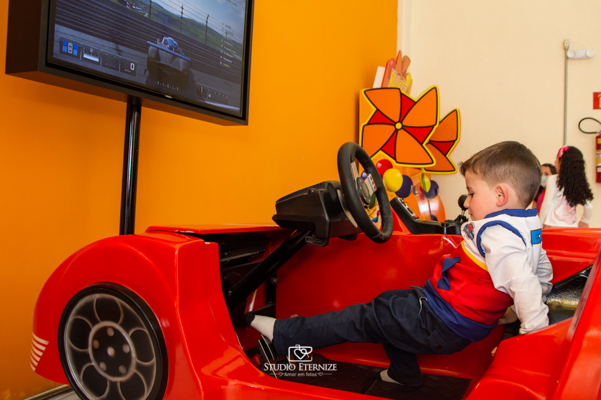 Fotografia de festa infantil de 3 anos registrada pelo Studio Eternize no tema da Patrulha Canina em no Buffet Cata-Vento em Poços de Caldas - MG. Aniversariante brincando no jogo de corrida.