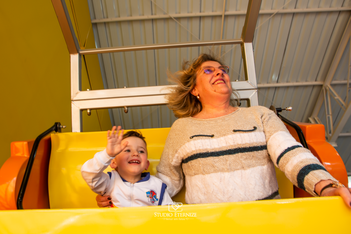 Fotografia de festa infantil de 3 anos registrada pelo Studio Eternize no tema da Patrulha Canina em no Buffet Cata-Vento em Poços de Caldas - MG. Aniversariante brincando com a avó no barco.
