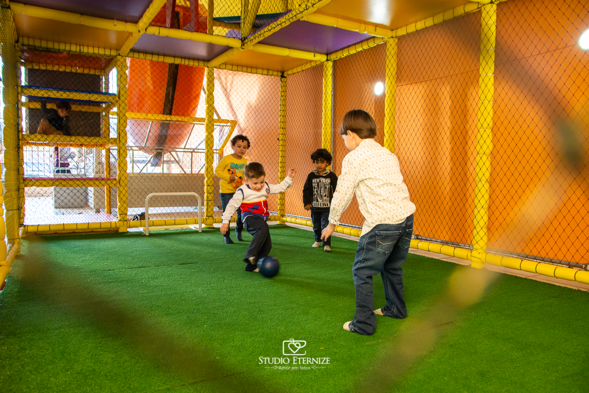 Fotografia de festa infantil de 3 anos registrada pelo Studio Eternize no tema da Patrulha Canina em no Buffet Cata-Vento em Poços de Caldas - MG. Aniversariante brincando de jogar bola.