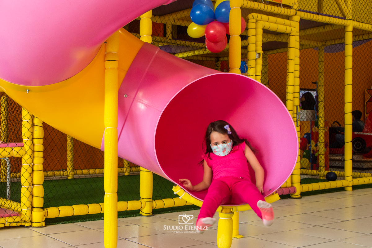 Fotografia de festa infantil de 3 anos registrada pelo Studio Eternize no tema da Patrulha Canina em no Buffet Cata-Vento em Poços de Caldas - MG. Criança brincando no escorrega.