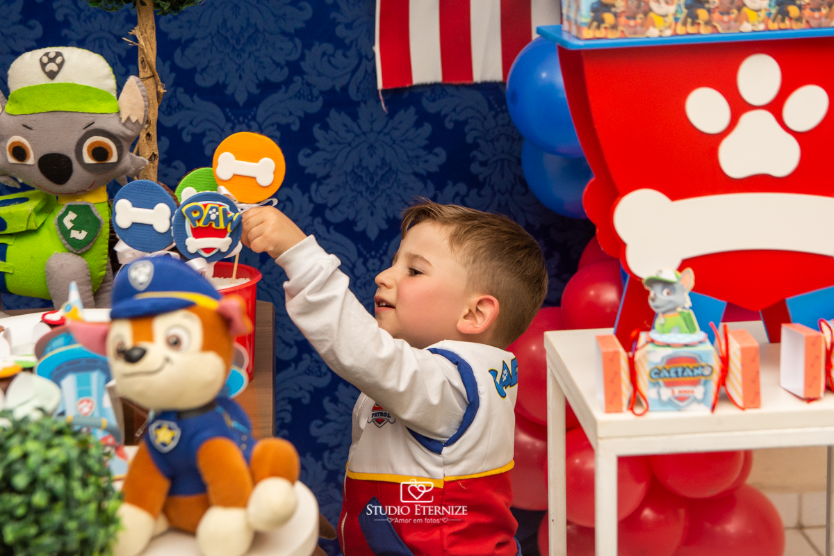 Fotografia de festa infantil de 3 anos registrada pelo Studio Eternize no tema da Patrulha Canina em no Buffet Cata-Vento em Poços de Caldas - MG. Aniversariante brincando com a decoração.
