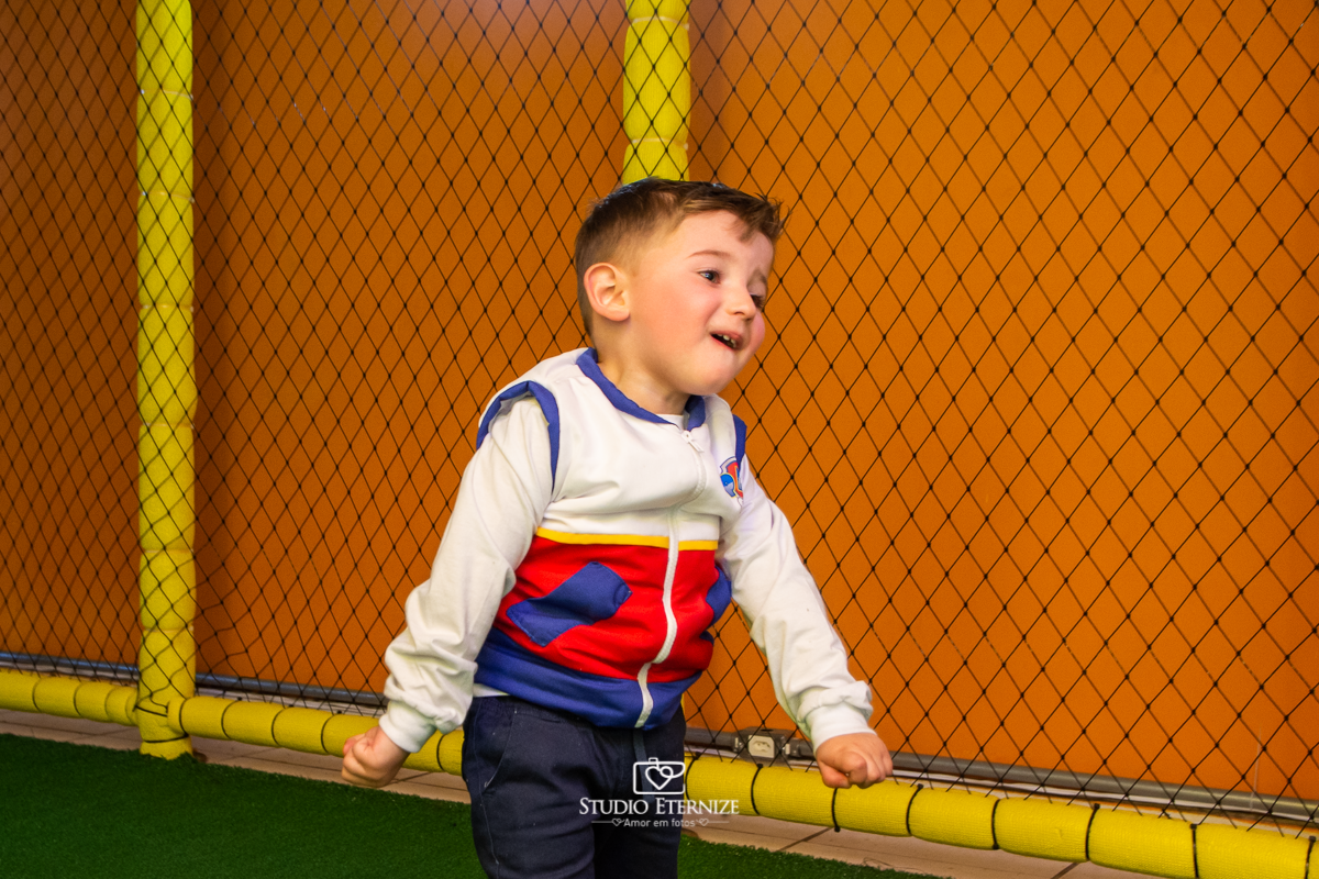 Fotografia de festa infantil de 3 anos registrada pelo Studio Eternize no tema da Patrulha Canina em no Buffet Cata-Vento em Poços de Caldas - MG. Aniversariante brincando de jogar bola.