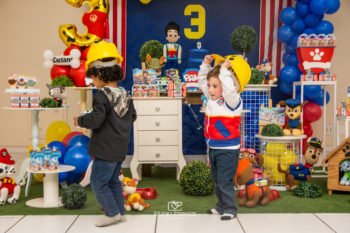 Fotografia de festa infantil de 3 anos registrada pelo Studio Eternize no tema da Patrulha Canina em no Buffet Cata-Vento em Poços de Caldas - MG. Aniversariante brincando com a decoração.
