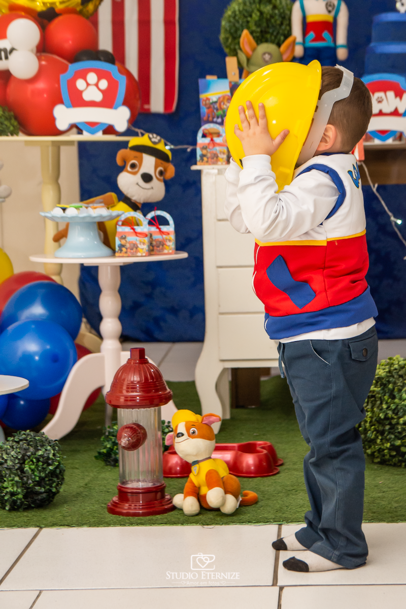 Fotografia de festa infantil de 3 anos registrada pelo Studio Eternize no tema da Patrulha Canina em no Buffet Cata-Vento em Poços de Caldas - MG. Aniversariante brincando com a decoração.