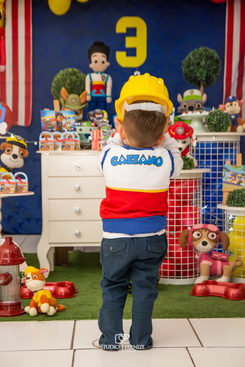 Fotografia de festa infantil de 3 anos registrada pelo Studio Eternize no tema da Patrulha Canina em no Buffet Cata-Vento em Poços de Caldas - MG. Aniversariante brincando com a decoração.