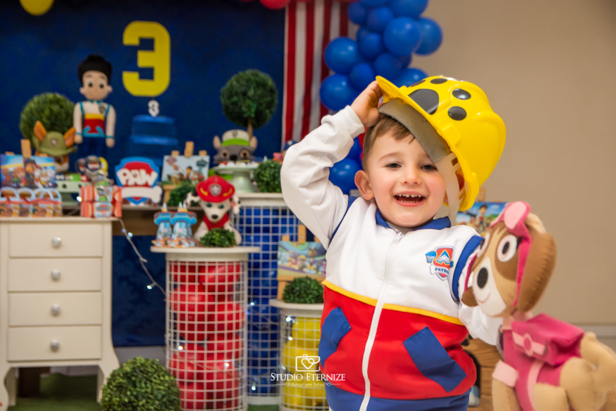 Fotografia de festa infantil de 3 anos registrada pelo Studio Eternize no tema da Patrulha Canina em no Buffet Cata-Vento em Poços de Caldas - MG. Aniversariante brincando com a decoração.