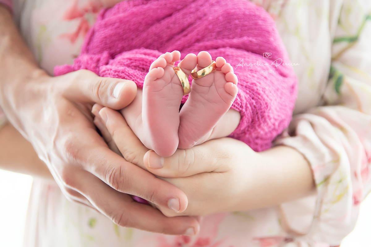 Fotografia newborn menina realizada em Poços de Caldas - MG. Pezinhos do bebê com as alianças.