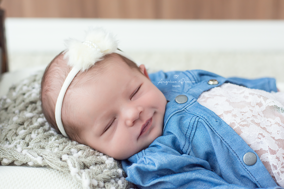 Fotografia newborn menina realizada em Poços de Caldas - MG. Bebê sorrindo.