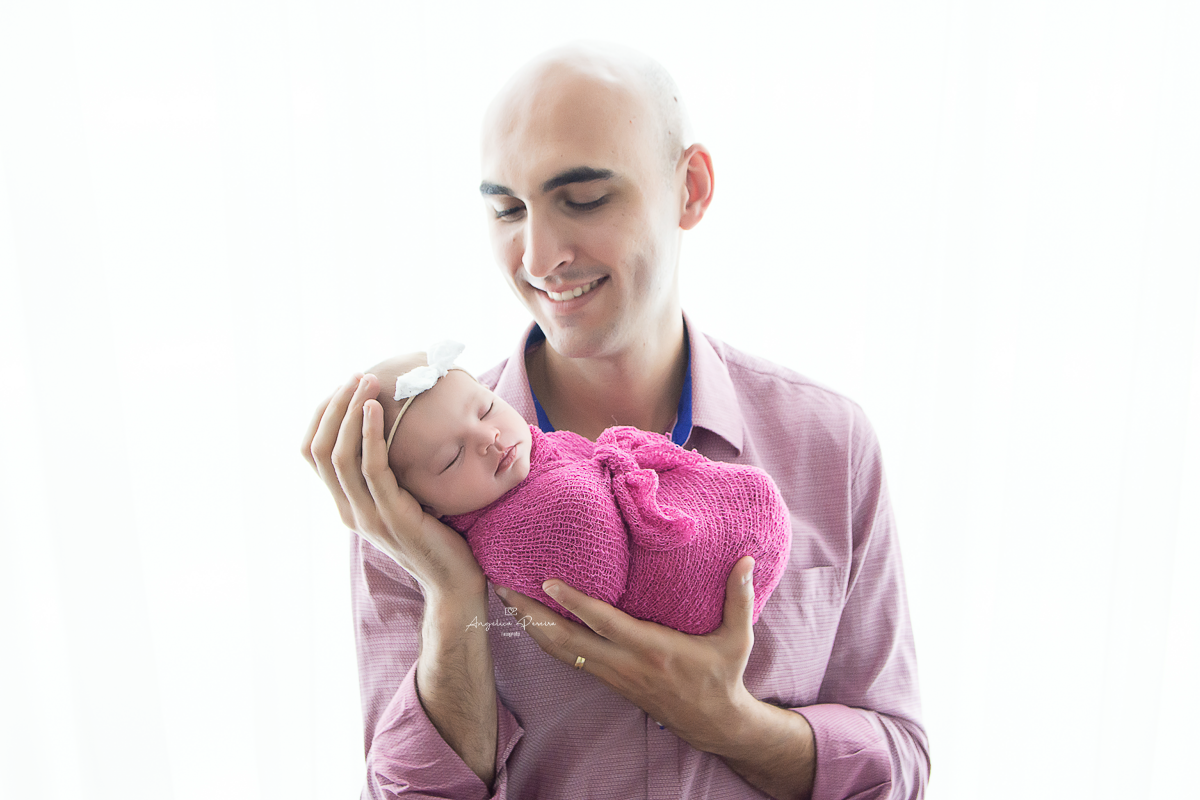 Fotografia newborn menina realizada em Poços de Caldas - MG. Bebê no colo do pai.