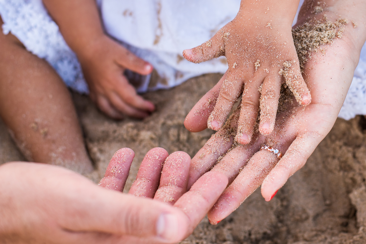 mãos-areia-pais-criança-brincando-praia-fotos