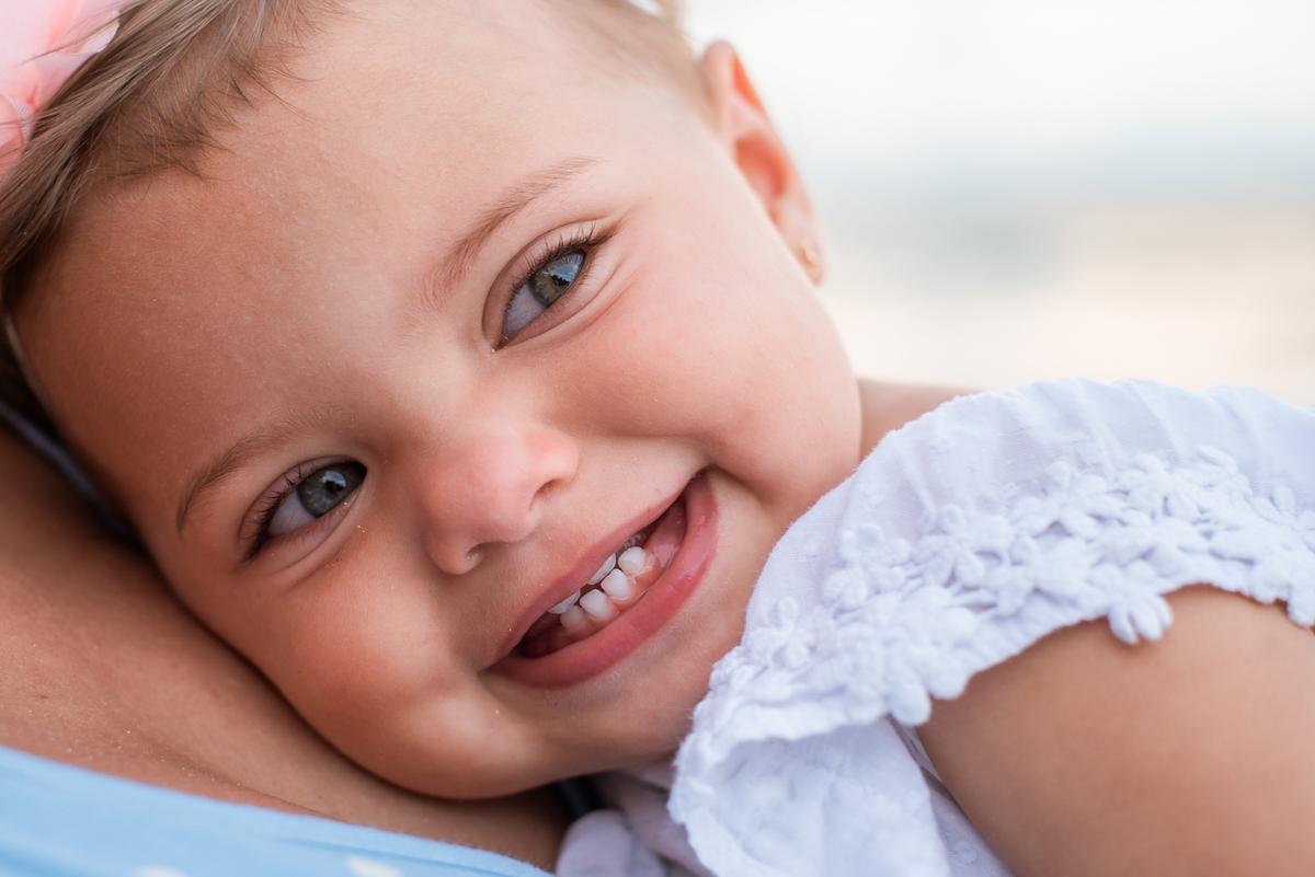 crianca-sorrindo-feliz-praia-colo-mãe-fotos