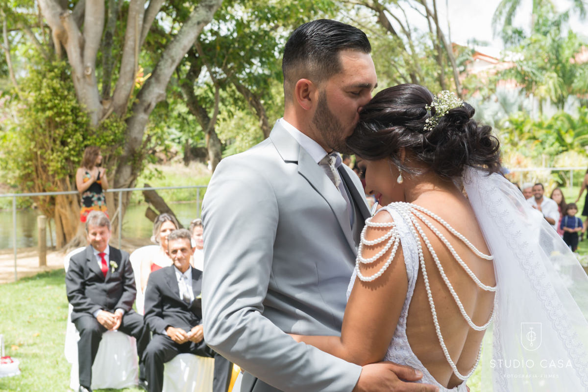 noivo beijando a noiva no altar